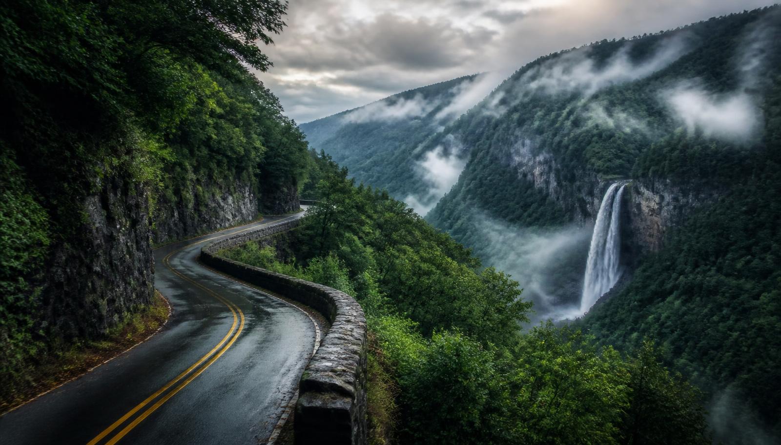 Misty mountain road winding past an Appalachian waterfall